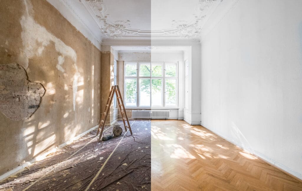A room split in half, showing one side old and damaged with exposed brick and dust, and the other side fully renovated with clean white walls and polished wood flooring—a striking look at home renovation. A ladder stands in the center.